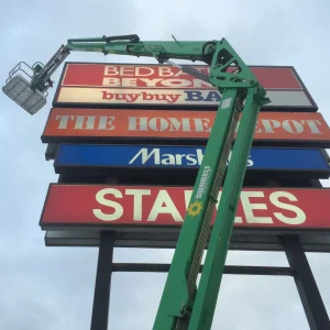 a bucket truck doing maintenance on pylon sign